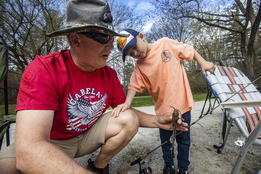 Feature - 3rd place - Rowen Underwood, 4, looks at the catfish he caught as his grandpa, Jeff Underwood holds it for him during a fishing day at Pearson Lake in Pearson Metropark in Oregon. (Rebecca Benson / The Blade)