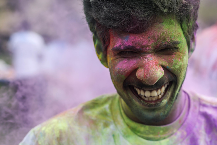 Portrait - 1st place - University of Toledo freshman Abhi Shek laughs while being fending off colored powder during the Holi Toledo Festival on the Memorial Fieldhouse lawn at the University of Toledo.  (Isaac Ritchey / The Blade)