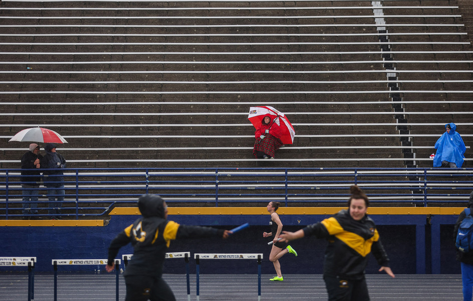 Sports Feature - 2nd place - Fans brave the rain as they watch the 4x100 meter relay during Whitmer's Nancy Erme Relays track and field meet at Whitmer High School in Toledo. (Rebecca Benson / REBECCA BENSON)