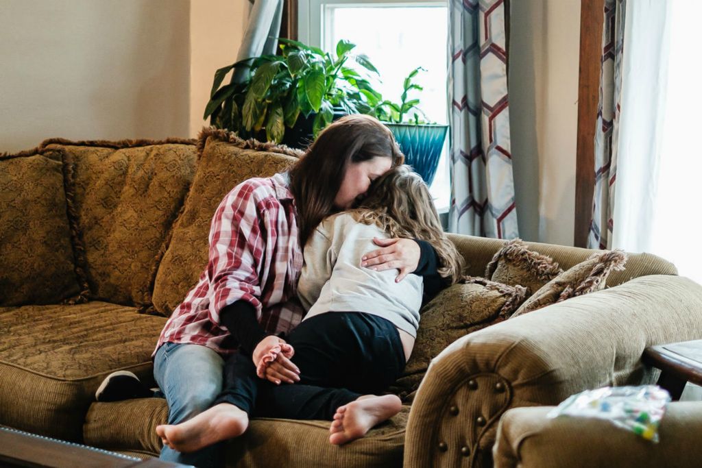 Feature - 1st place - Heather Pereces, snuggles her daughter Brooklyn, 6, in their Uhrichsville home. Brooklyn, who is on the Autism spectrum, is among seven children raised by Heather - two from a previous marriage, and two adopted, and three with her current husband. (Andrew Dolph / The Times Reporter)