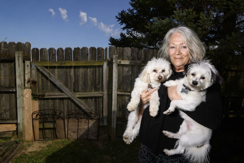 Portrait - 1st place - Joyce Clemens feeds her dogs Jake and Zoe grain free food during Passover in Elmore.  (Jeremy Wadsworth / The Blade)