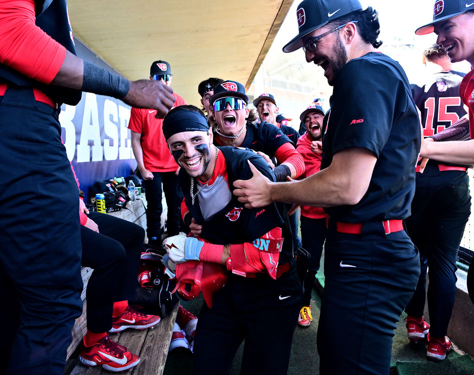 Sports Feature - 1st place - Dayton's Nolan Watson gets swarmed by his teammates in the dugout after hitting a home run against George Mason. The Flyers defeated George Mason 17-14. (Erik Schelkun / Elsestar Images)