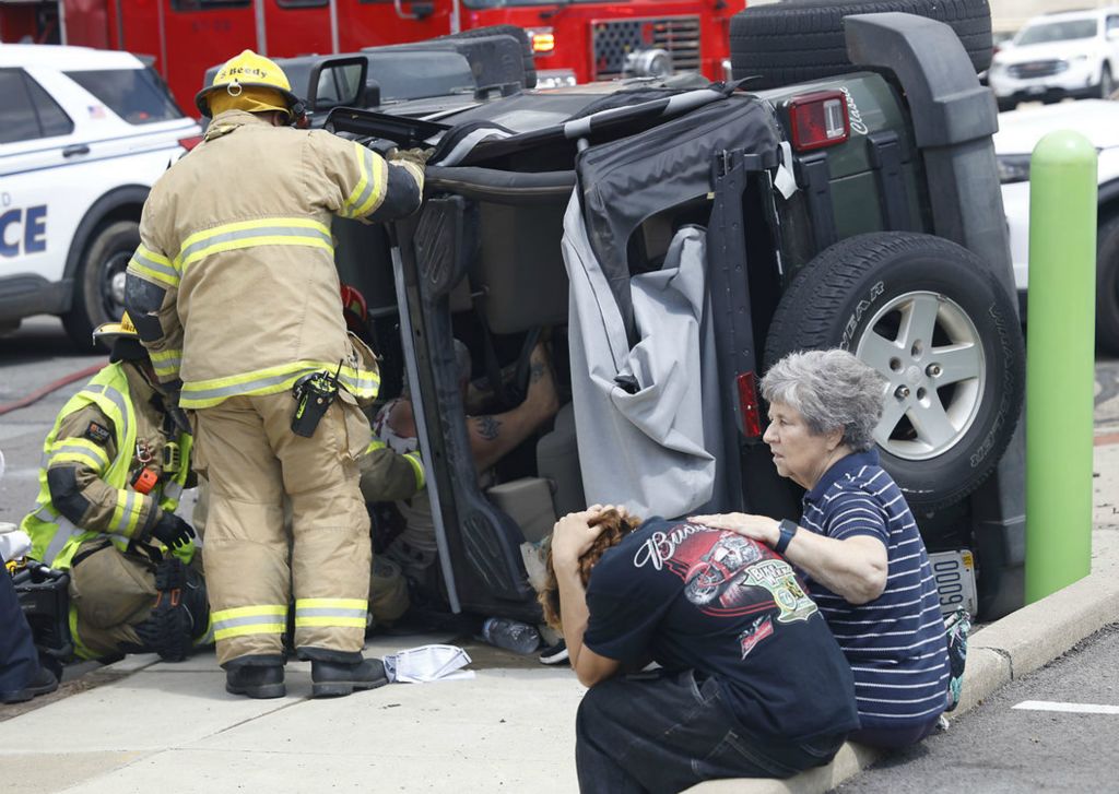 Spot News - 1st place - The young driver involved in a two vehicle accident is comforted by a bystander at the intersection of North Street and Fountain Avenue. The two people in the Jeep in the background had to be rescued from their overturned vehicle. They were transported to the hospital with non-life threatening injuries. The accident closed the intersection for a half hour while it was cleaned up. (Bill Lackey / Springfield News-Sun)