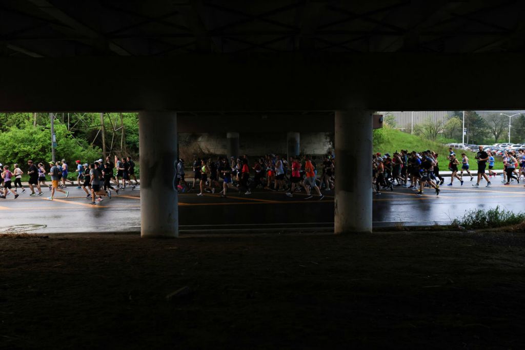 Sports - 1st place - Runners make their way under the Upton Avenue bridge as they begin the 2024 Glass City Marathon in Toledo. (Rebecca Benson / The Blade)