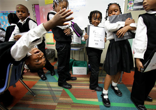 Feature - HM - Entrepreneurship Preparatory School student Mario Burks, 6, (left) stretches in his chair at the end of the school day as his classmates line up at the door to leave.  E-Prep, in Cleveland, is a charter school that gets good academic results.  (Lisa DeJong / The Plain Dealer)