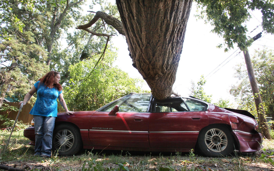 Spot News - 3rd placeKelly Boyd leans against her boyfriends Thomas Ree's car at her Clintonville home. Her landlord has yet to remove the tree from the yard from previous storms. (Eric Albrecht / The Columbus Dispatch)