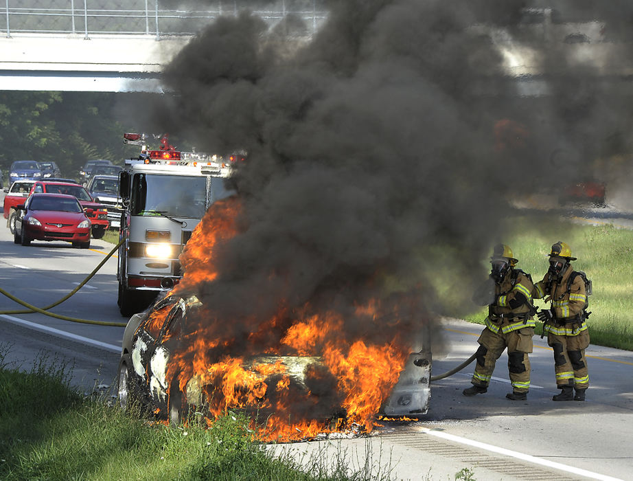 Spot News - 2nd placeMembers of the Springfield Township Fire Division battle a fully engulfed car fire on SR 4 near the Old Mill Road bridge that completely closed the southbound lanes of the the highway while the car was extenguished.  (Bill Lackey / Springfield News-Sun)