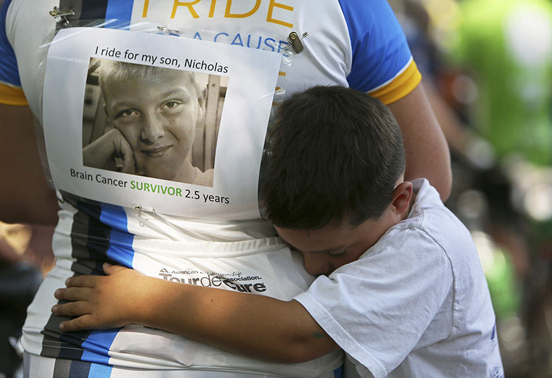 General News - 2nd place - Matthew Sawchuk, 7, embraces his mother Jennifer, just after she finished the Pelotonia 100-mile ride for cancer awareness, in Columbus. Jennifer rode for Matthew's brother, Nicholas Sawchuk, 13, who is a two-and-a-half year survivor of brain cancer. Nicholas and his twin brother Benjamin were present at the race as well.  (Jenna Watson / The Columbus Dispatch)