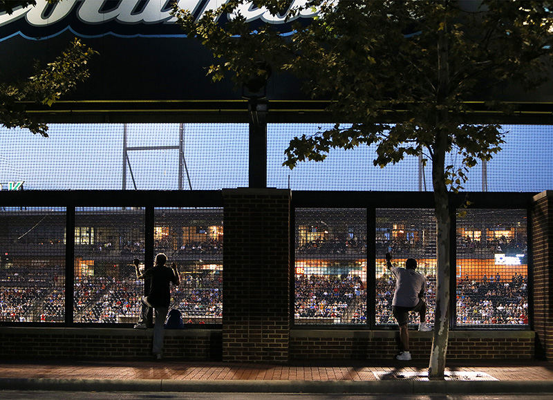 Sports Feature - 2nd place - Spectators watch from outside of Huntington Park as the Columbus Clippers take on the Indianapolis Indians in Columbus. (Jenna Watson / The Columbus Dispatch)