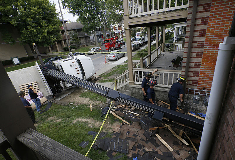 Spot News - 2nd place - Columbus police and firefighters respond to a lift truck that had tipped over on East Chittendon Avenue near Ohio State's campus. The truck was delivering shingles to the roof of an apartment building when it fell on its side. No one was hurt in the accident, but the apartment suffered significant exterior damage.  (Adam Cairns / The Columbus Dispatch)