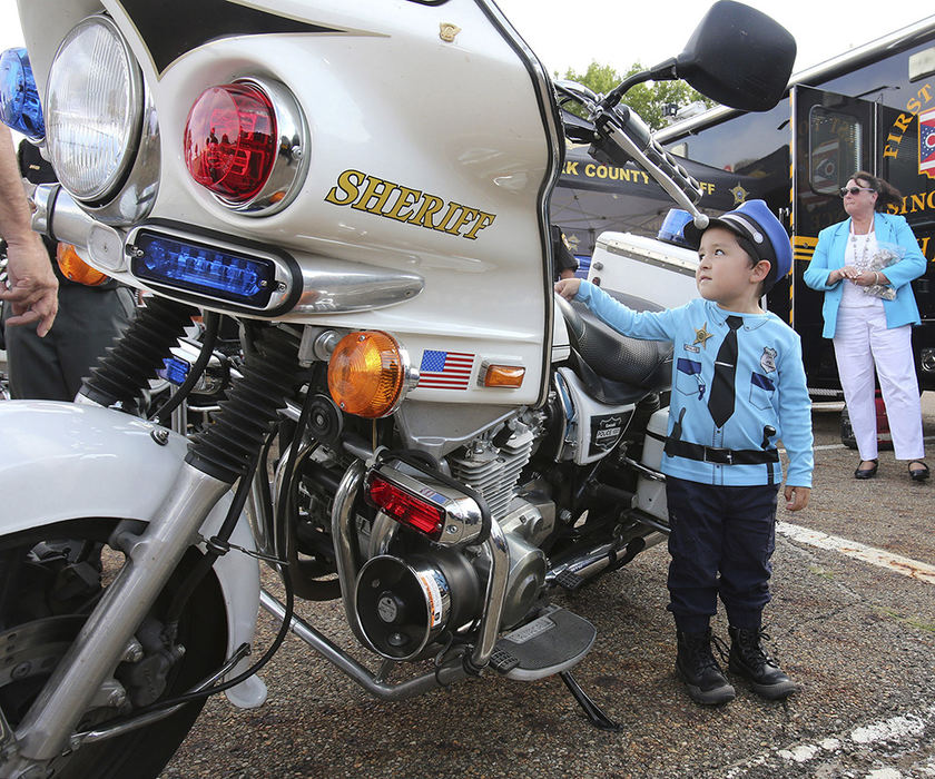 Feature - HM - Diego Villafranca wore his police uniform while checking out a Stark County Sheriff Department motorcycle during National Night Out in the parking lot of Target in Massillon.  (Scott Heckel / The Repository)