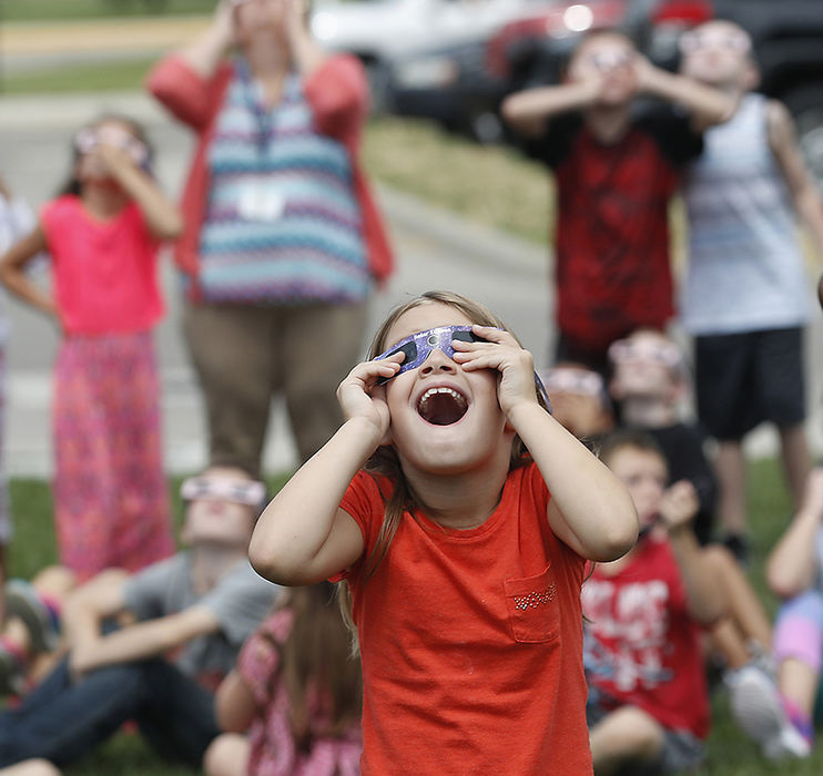 General News - 2nd place - A young student at Horace Mann Elemantary seems amazed as the clouds break up revealing the solar eclipse. (Bill Lackey / Springfield News-Sun)