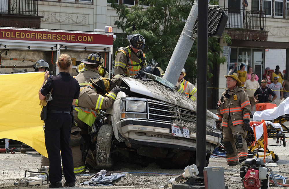 Spot News - 2nd place - Toledo firefighters work to extricate a victim following a fatal accident in the 1300 block of West Sylvania at Overland Parkway in West Toledo.   (Jeremy Wadsworth / The Blade)