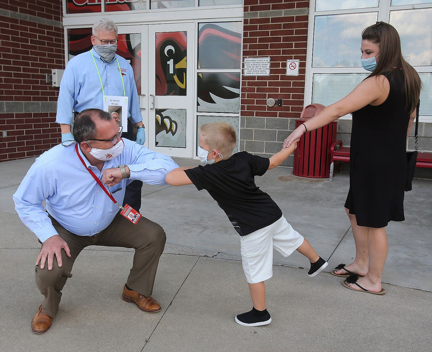 Feature - 2nd place - David Fischer, superintendent at Sandy Valley Local School District, elbow bumps with Ryker Reid-Polka upon the younger's arrival for an open house at Sandy Valley Elementary School. Also visible is the school's principal Vic Johnson and Ryker's mother Angela Polka. Scott Heckel / The Canton Repository