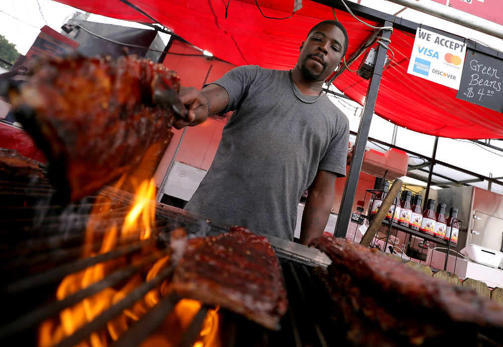 Feature - 2nd placeLaquan Joyner, with Porky Chicks BBQ, works the grill during day two of the Northwest Ohio Rib Off at the Lucas County Fairgrounds in Maumee. (Kurt Steiss / The Blade)