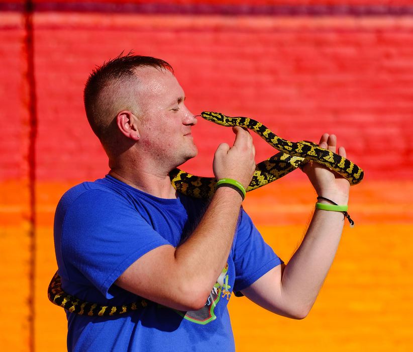 Feature - 3rd placeJake "The Snake" Burchell, owner of  Frog Town Exotics, with his jungle carpet python, Cleveland, at the Market on the Green during the Art Loop. (Jeremy Wadsworth / The Blade)