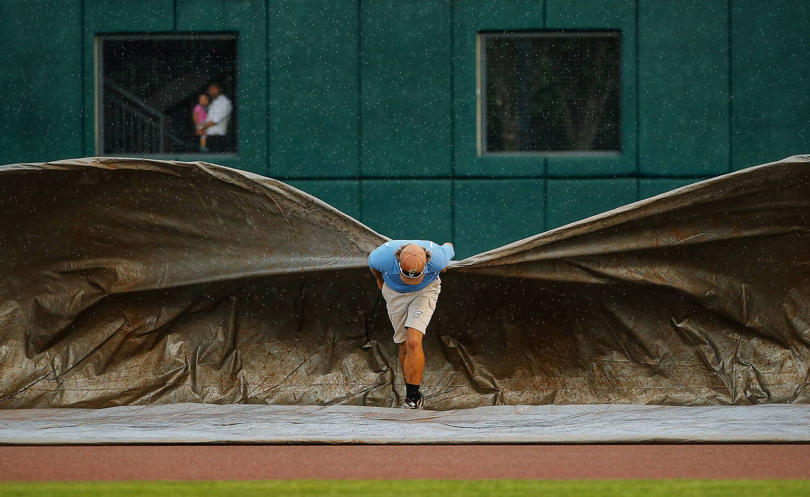 Sports Feature - 1st placeColumbus Clippers grounds crew manager of field operations Cory Merriman pulls the tarp over the field as a brief rain shower passes by prior to the a game against the Pawtucket Red Sox at Huntington Park in Columbus. The game started 45 minutes late as a result. (Adam Cairns / The Columbus Dispatch)