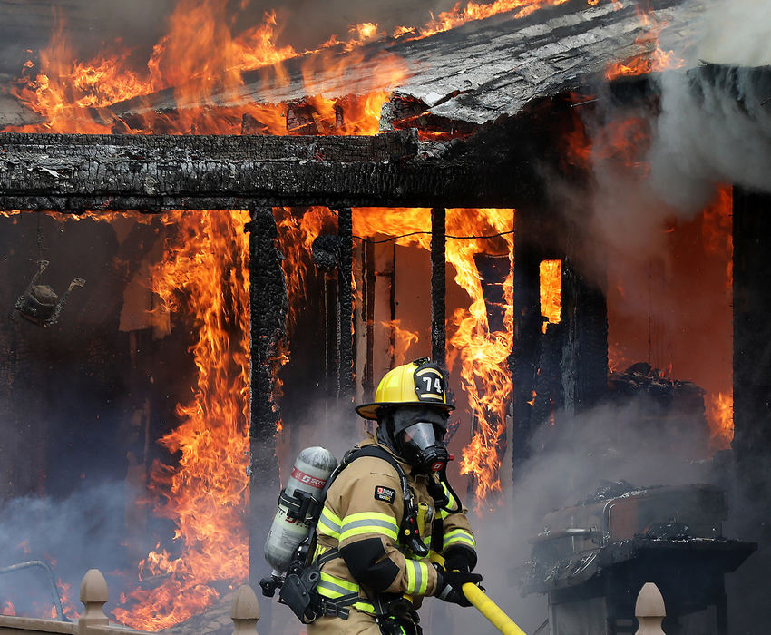 Spot News - 1st placeA Moorefield Township firefighter drags his firehose into position as he prepares to attack a fully involved house fire along Thomaston Trail. The owners of the home were not home at the time of the blaze. The structure was a total loss.  (Bill Lackey / Springfield News-Sun)