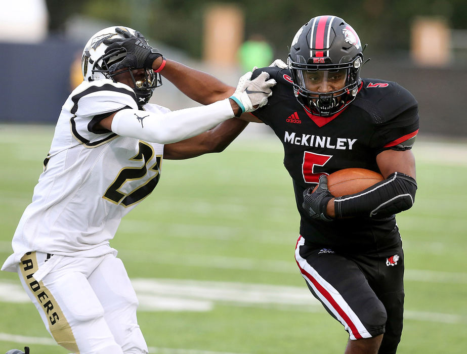 Sports - 3rd placeMcKinley's Lameir Garrett stiff-arms Warren Harding's Marcus Wilkins during the first quarter of their game at Tom Benson Hall of Fame Stadium in Canton. (Scott Heckel / The Canton Repository)