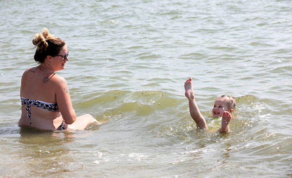 Feature - HM - Melissa Kroon of Flat Rock, MI watches her daughter Avery Kroon, 3, swim in Lake Erie on a sweltering afternoon in Luna Pier, Michigan. (Amy E. Voigt / The Blade)