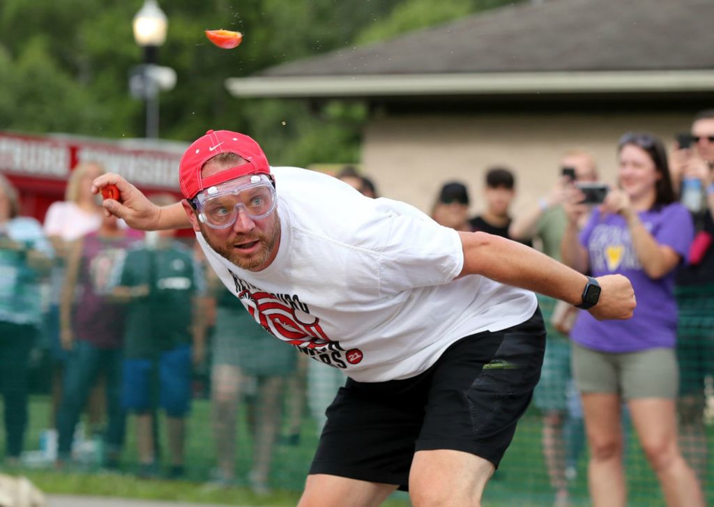 Feature - HM - Mike Haringa, of Pickerington, ducks an incoming tomato as he launches one of his own during the Tomato Wars events at the Reynoldsburg Tomato Festival at Huber Park. Haringa's team, the Tomatonators, won the competition for the second year in a row. All proceeds from the event are to be donated to the Mid-Ohio Market at HEART. (Shane Flanigan / ThisWeek Community News)