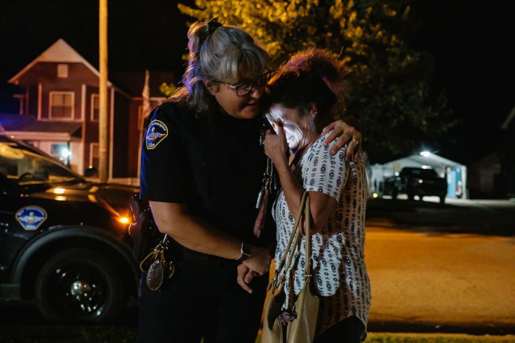 Spot News - 1st place - Debby Bair is embraced by New Philadelphia Police Officer Wendy Jones after Debbie's car caught fire and was extinguished in the parking lot of the East Central Ohio Educational Service Center in New Philadelphia.   (Andrew Dolph / The Times Reporter)