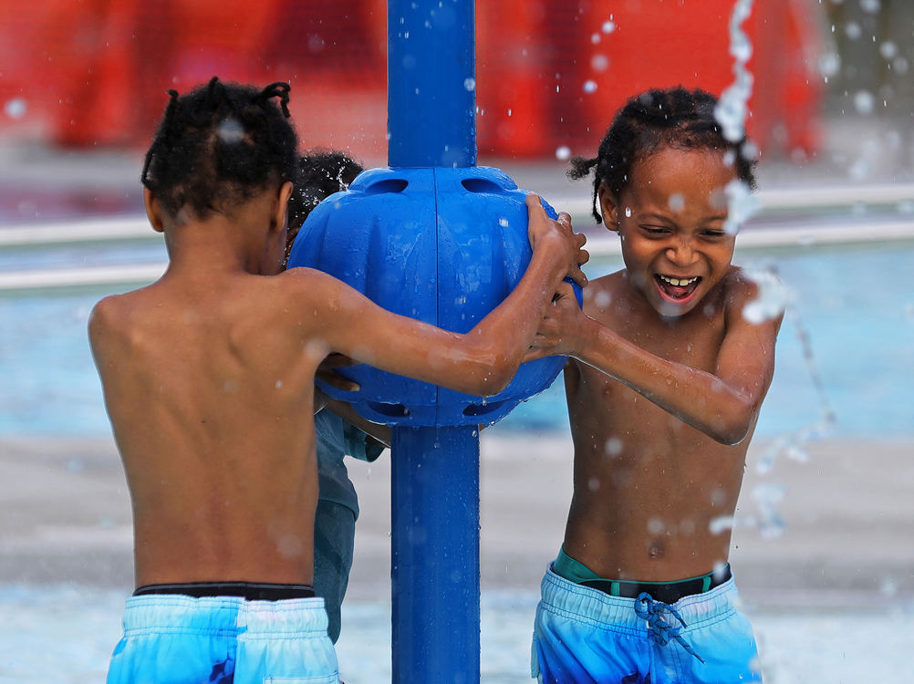 Feature - 1st place - Jaison Shepherd  (right) plays in one of the water fountains with his twin brother Jayden during the opening celebration for the Perkins Woods Pool in Akron. (Jeff Lange / Akron Beacon Journal)