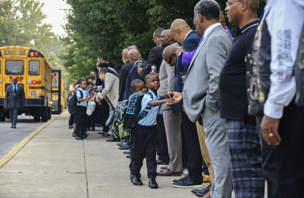 Feature - HM - Officials and community members greet students on the first day of school at MLK Jr. Academy for Boys in Toledo.  (Jeremy Wadsworth / The Blade)