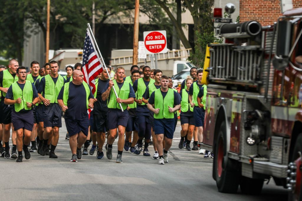 General News - 2nd place - Recruit Joshua Close (with flag) leads Toledo Fire Class 297 to finish a “legacy run” near the Toledo Firefighters Memorial on Beech Street in Toledo. (Isaac Ritchey / The Blade)