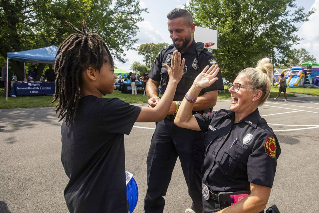 General News - 3rd place - Lieutenant Gina Shubeta high fives Ma’Khi Finn, 8, after he correctly answered a question during National Night out at the Frederick Douglass community center in Toledo. (Rebecca Benson / The Blade)