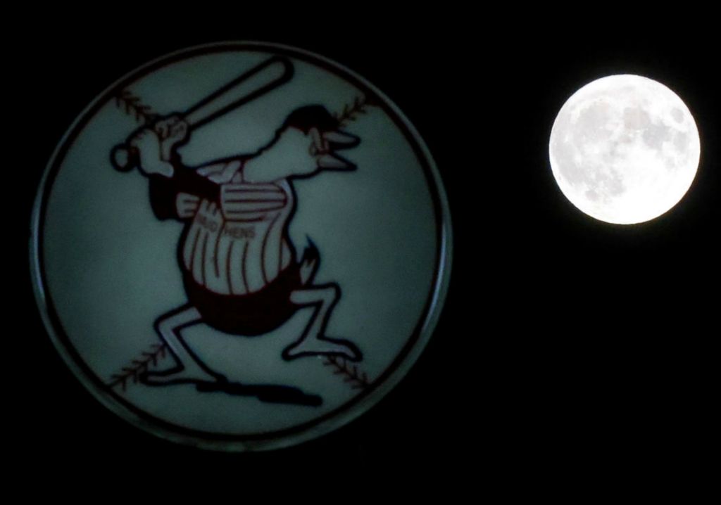 General News - HM - The Toledo Mud Hens logo on the Swamp Shop sign looks as though it's swinging at the full moon after the Hens’ 7-1 loss to the Iowa Cubs in an International League baseball game at Fifth Third Field in Toledo. (Kurt Steiss / The Blade)