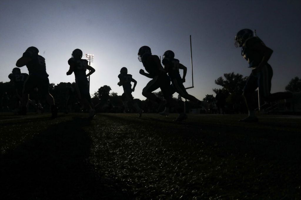 Sports Feature - 1st place - Findlay enters the field before the start of a high school football game at Donnell Stadium in Findlay. (Rebecca Benson / The Blade)