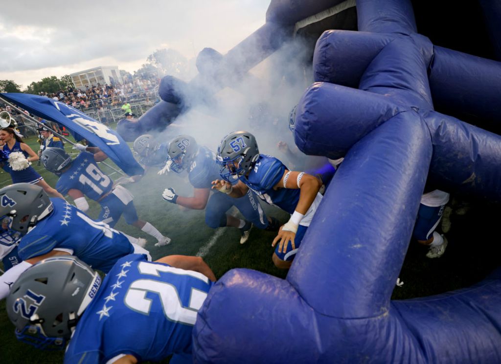 Sports Feature - HM - Anthony Wayne football players head out of an inflatable helmet ahead of a high school football game against St. John’s Jesuit at Anthony Wayne High School in Whitehouse, Ohio. (Kurt Steiss / The Blade)