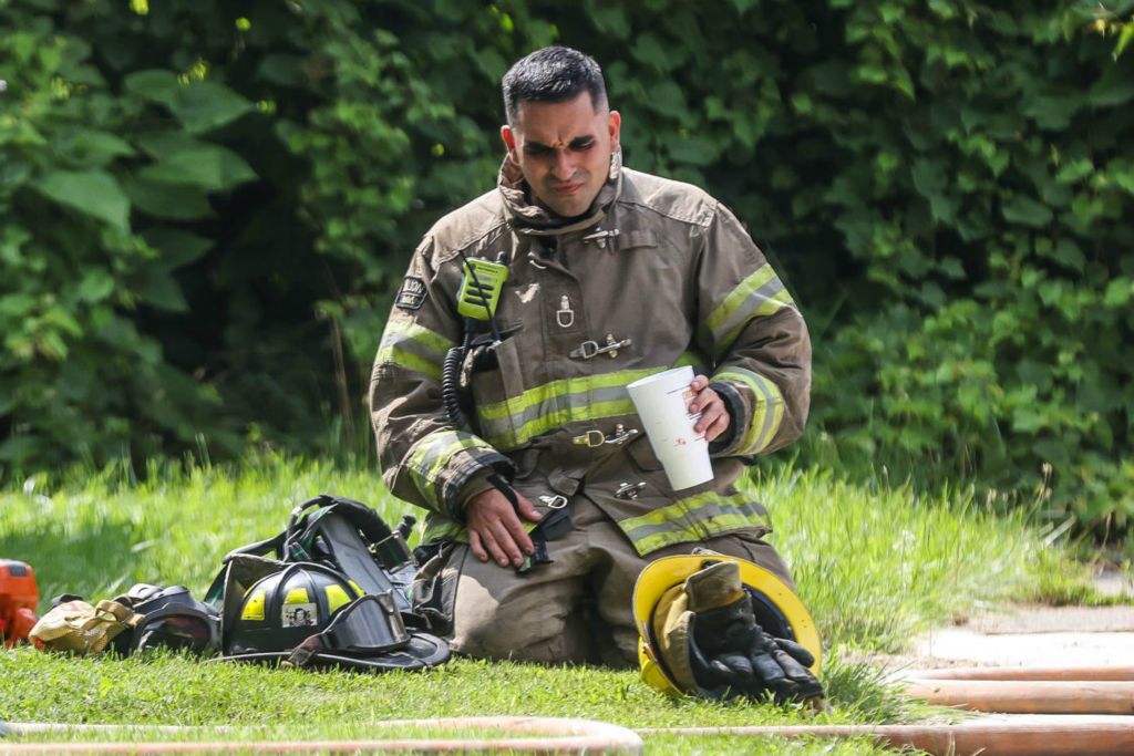 Spot News - 3rd place - A Toledo Fire and Rescue Department officer grimaces while having a drink after helping extinguish a fatal fire on Klondike Street in Toledo.  (Isaac Ritchey / The Blade)