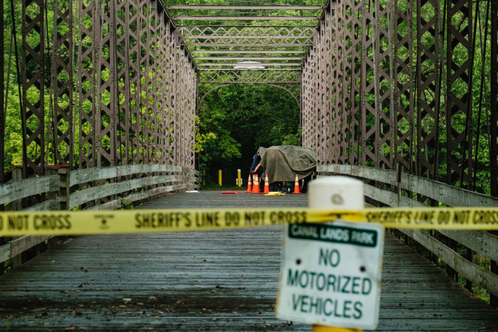 Spot News - HM - Firefighters and medics from the Bolivar Fire Department assist detectives from the Tuscarawas County Sheriff's Office with the identification of a person who was found shot to death on the historic Zoar Iron Bridge in Lawrence Township. According to detectives on scene, 'a note was found' suggesting that it was a suicide. (Andrew Dolph / The Times Reporter)