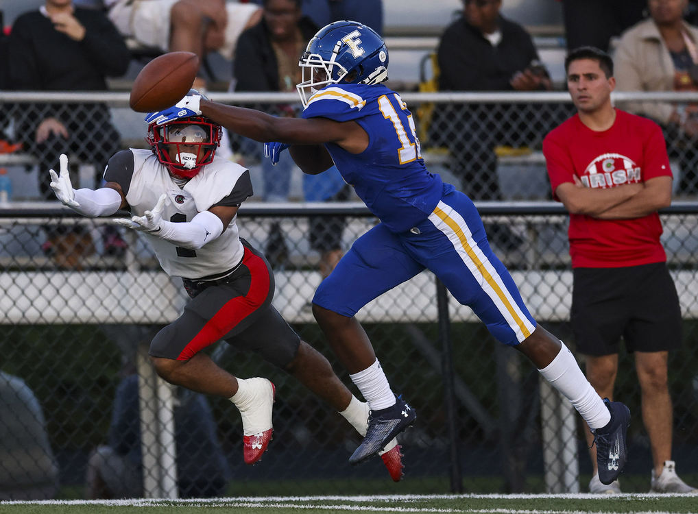 Sports - HM - Central Catholic’s Jayden Watson dives for an incomplete pass against Findlay’s Israel Moore during a high school football game at Donnell Stadium in Findlay. (Rebecca Benson / The Blade)