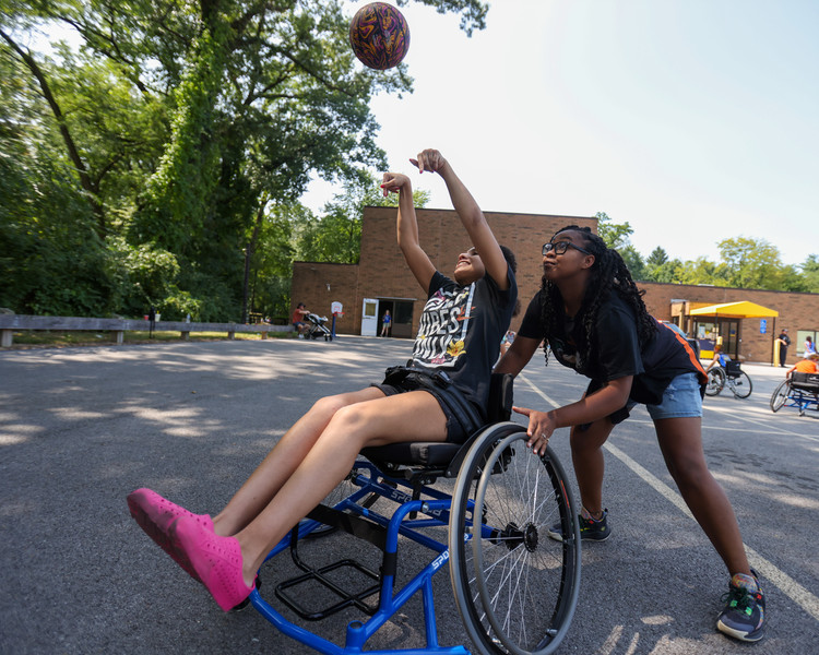 Feature - 2nd place - Chloe Hereford shoots a basket while Nadia Foulks cheers her on during Family fun day at The Ability Center in Sylvania.  (Jonathan Aguilar / The Blade)   (Jonathan Aguilar / The Blade)