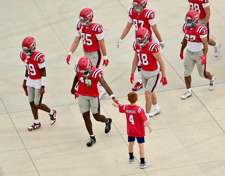 Sports Feature - HM - Dayton's Dillon Fitzpatrick hands out a high five to a lone fan as the team enters Welcome Stadium prior to the start of the season opening game against St. Francis. (Erik Schelkun / Elsestar Images)   (Erik Schelkun / Elsestar Images)