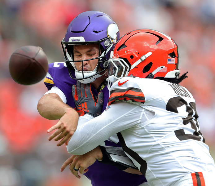 Sports - 3rd place - Minnesota Vikings quarterback Nick Mullens (12) takes a hit from Cleveland Browns linebacker Devin Bush (30) during the first half of a preseason game at Cleveland Browns Stadium. (Jeff Lange / Akron Beacon Journal)   (Jeff Lange / Akron Beacon Journal)