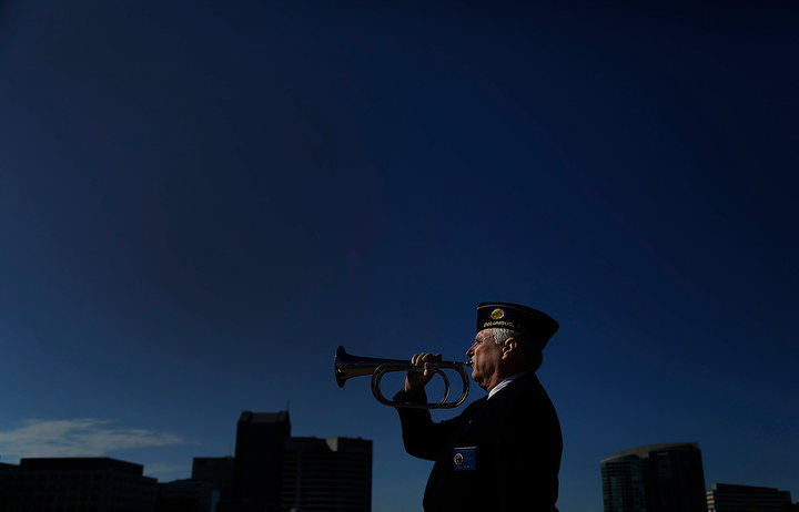 May - 2nd place feature - Richard Rozzell of American Legion Navy Marine Post 276 plays "Taps" after lowering of a flowered anchor off of the Broad St. bridge in downtown Columbus during Memorial Day. This was the 100th year that the post has provided this service on the Scioto River, through wars and crises and they have never missed a year. (Kyle Robertson / The Columbus Dispatch)