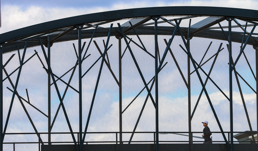 March - Feature - 1st place - A person jogs across the pedestrian bridge over Main Street in Toledo.   (Jeremy Wadsworth / The Blade)