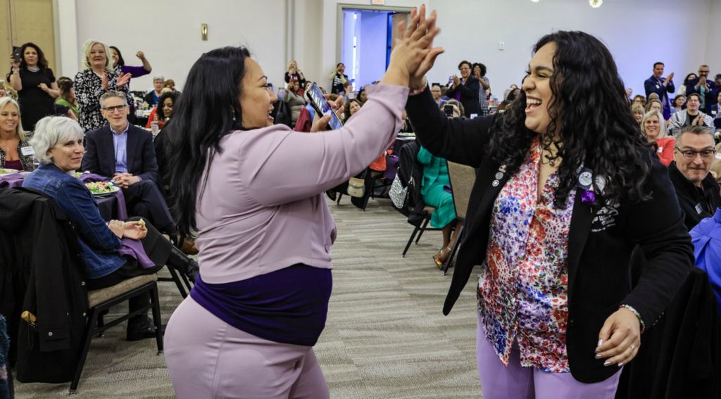 March - General News - 3rd place - Nina Corder (left) and Sierra Ortiz high five each other during the International Women's Day Signature Luncheon at the Hilton in Toledo.   (Jeremy Wadsworth / The Blade)