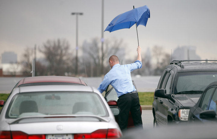 Feature - 2nd place - Jeremy Parkins' umbrella lost its battle against the rainstorm that blew through Columbus. The Columbus Crew's director of soccer business development had to run something out to an associate in the parking lot. He didn't return to his office at Crew Stadium dry.  (Shari Lewis / The Columbus Dispatch)