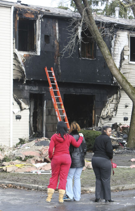 Spot News - 1st place - Neighbors, friends and onlookers stand in font of a town-house apartment where a fire killed two young sisters on the southeast side of Columbus.  (Neal C. Lauron / The Columbus Dispatch)