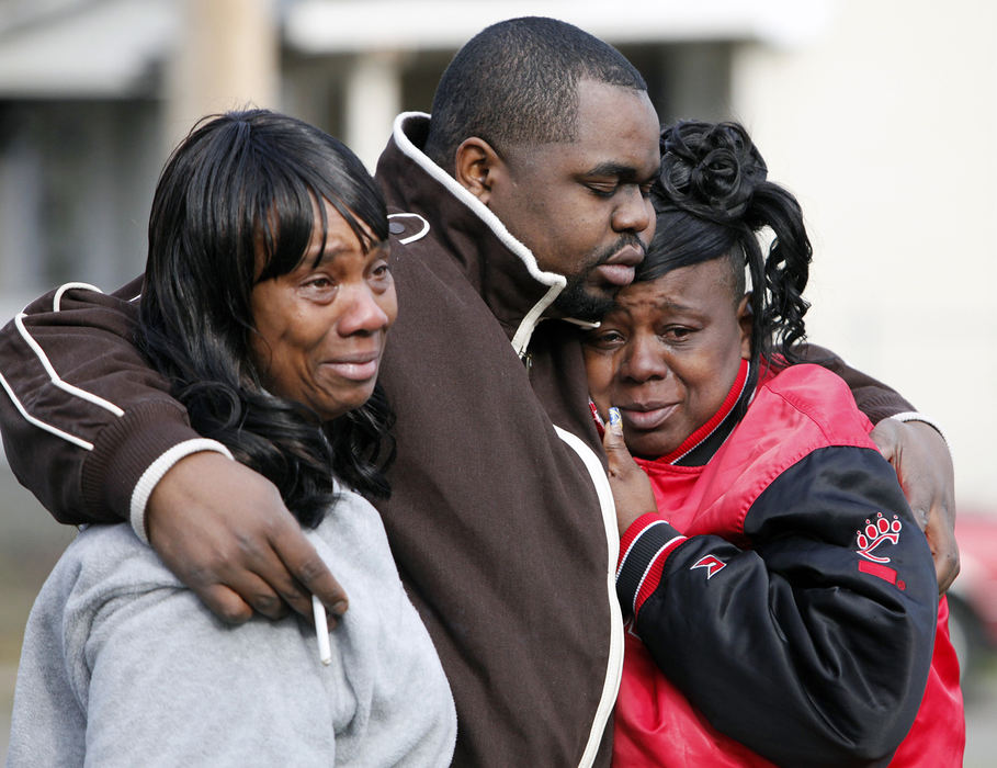 Spot News - 2nd place - Alan Pressley (center) hugs family members Dabrina Oates (left) and Veronica Johnson, outside a house where three people, their niece and great nephew, were found dead after firefighters responded to a blaze at 90 Wisconsin Ave in Franklinton on Christmas eve night. (Kyle Robertson / The Columbus Dispatch)