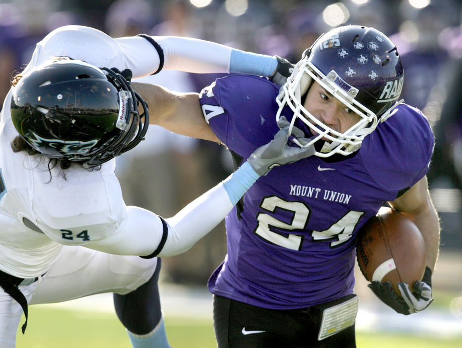 Sports - HM - Wesley College's Michael Brandenburg grabs the face mask of Mt. Union's Jeremy Murray during a drive that resulted in a Purple Raiders' touchdown. Brandenburg was penalized on the play. (Scott Heckel / The (Canton) Repository)