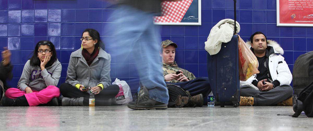 General News - HM(From left) Muskaan Ali and her sister Hafsa Ali joined Jordan Hamilton and Emran Kabir sitting on the floor of the Greyhound bus station in North Fourth Street after their bus to Indianapolis was cancelled due to severe weather. (Chris Russell / The Columbus Dispatch )