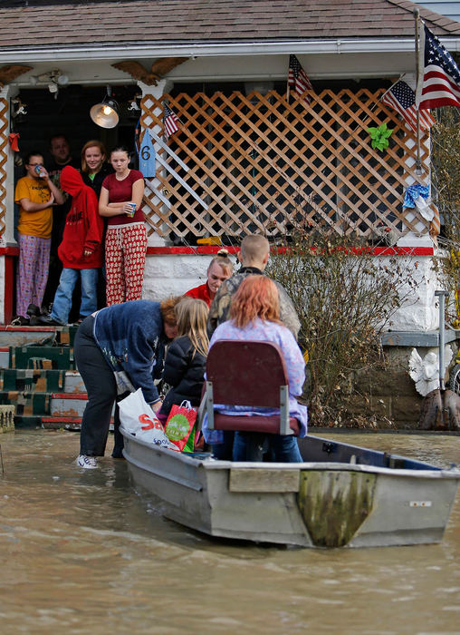 Spot News - 2nd placeJennifer Pendleton, (left) and her sister-in-law Edna Pendleton (right) pull a rowboat full of their children, along with groceries and supplies in to the front porch of Edna's home on Chestnut Street in La Rue, Ohio. Severe flooding submerged the family's entire front yard in more than four inches of water, as well as filling the crawl space underneath their home. (Sam Greene / The Columbus Dispatch)