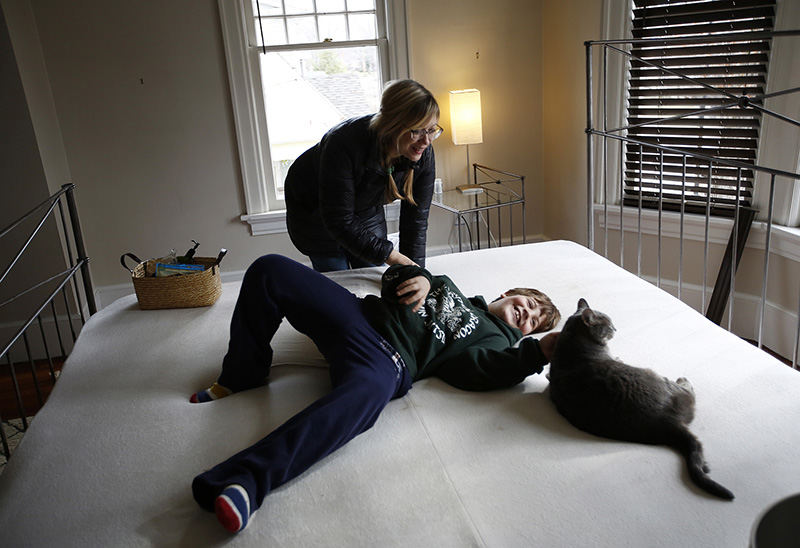 Feature - 3rd place - Anne Gerdes tickles her son Liam, 8, and tells him he's got to get back to school as he lays in her bed and plays with one of their cats, Beanie, while their family moves across the street on West 1st Avenue in Grandview. The Kalnow's have always had their eye on Anne Gerdes' big old house and corner lot, so the second she put out a for sale by owner sign they walked across the street to inquire. A weird sequence of events fell into place culminating with the two families buying each other's homes and moving across the street.  (Eamon Queeney / The Columbus Dispatch)