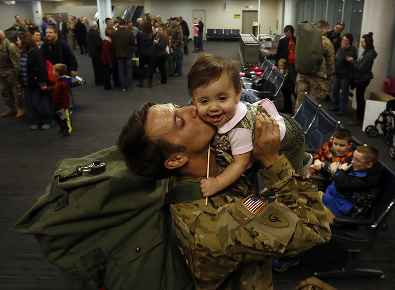 General News - 2nd place - Heath Tucker with the Ohio National Guard's 1st Battalion, 137 Regiment, returning from Kuwait, kissing his daughter Quinn, 9 months, for the first time at Port Columbus International Airport.  (Tom Dodge / The Columbus Dispatch)